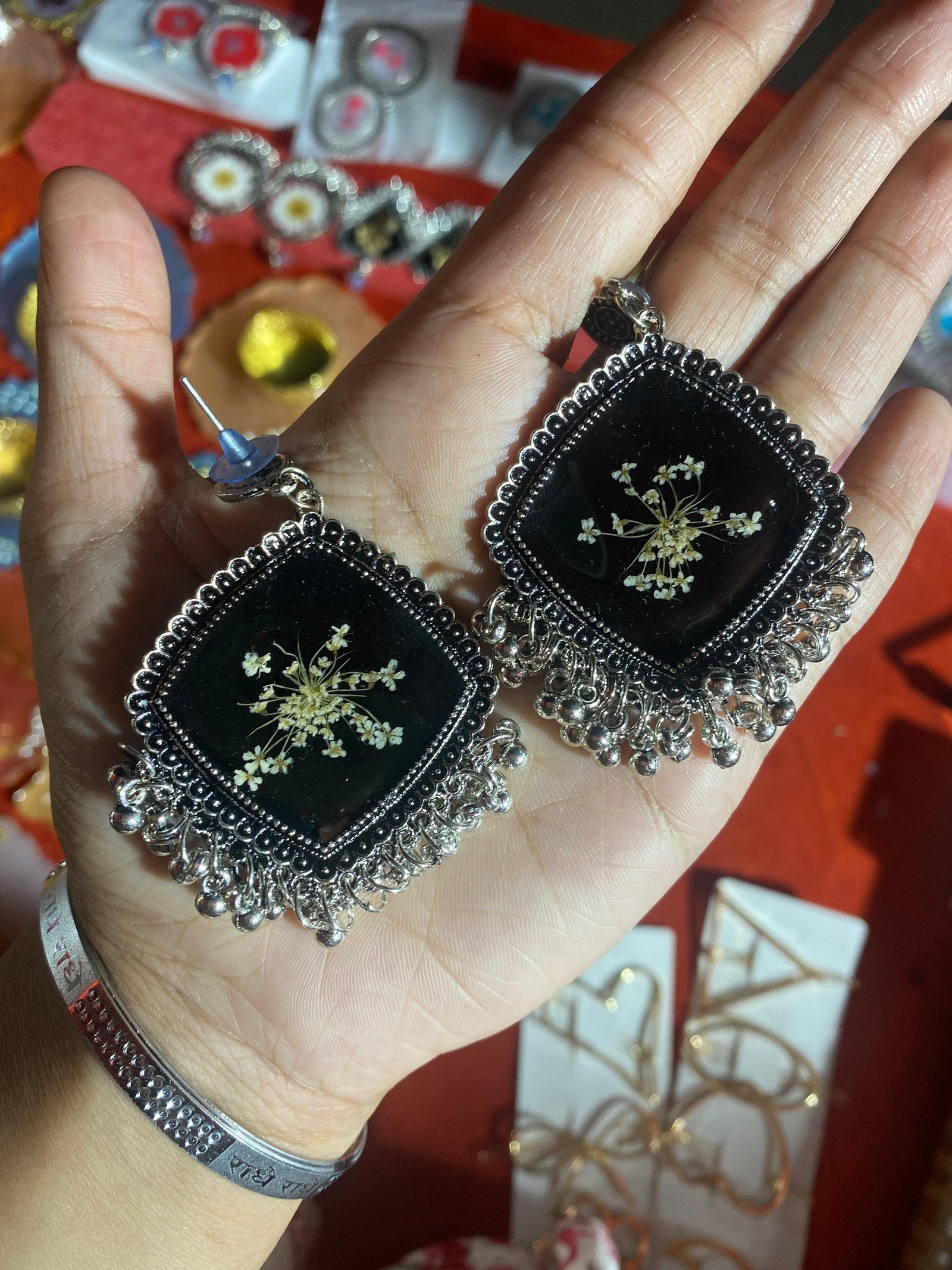 A darker version, black resin set with white flowers, held in the hand