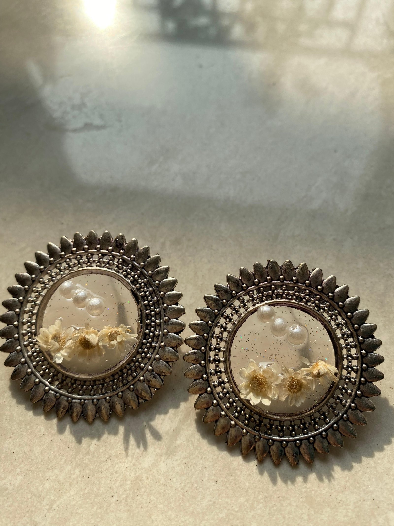 A pale pair holding cream flowers and a pearl