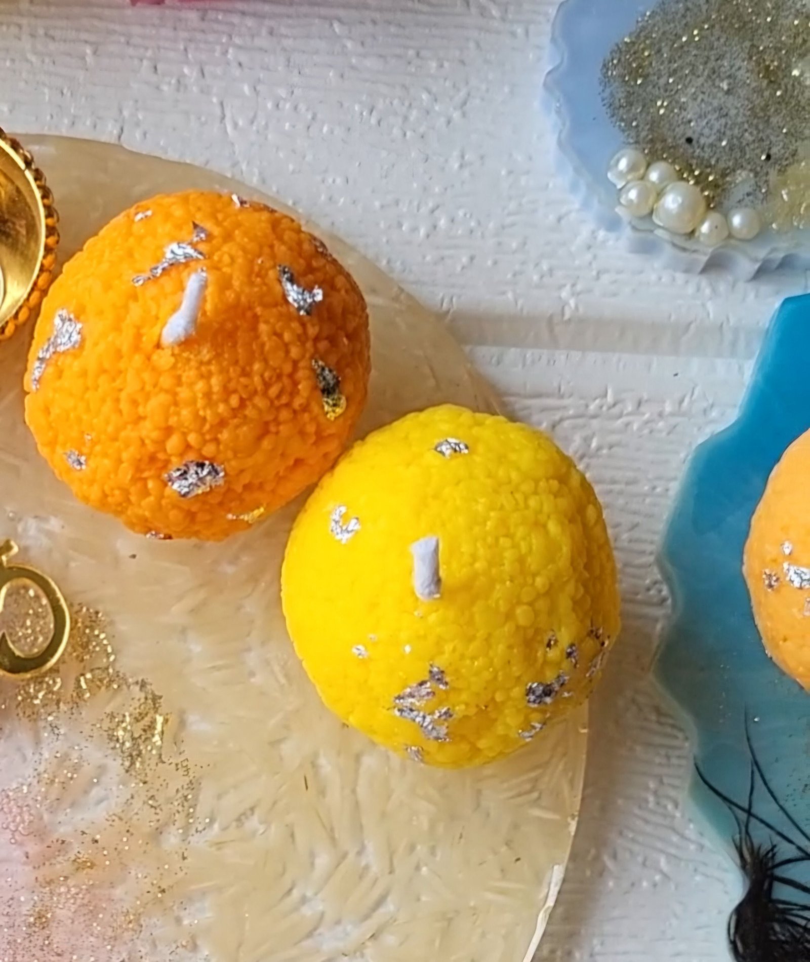 Laddoo-shaped candles on a marbled resin tray