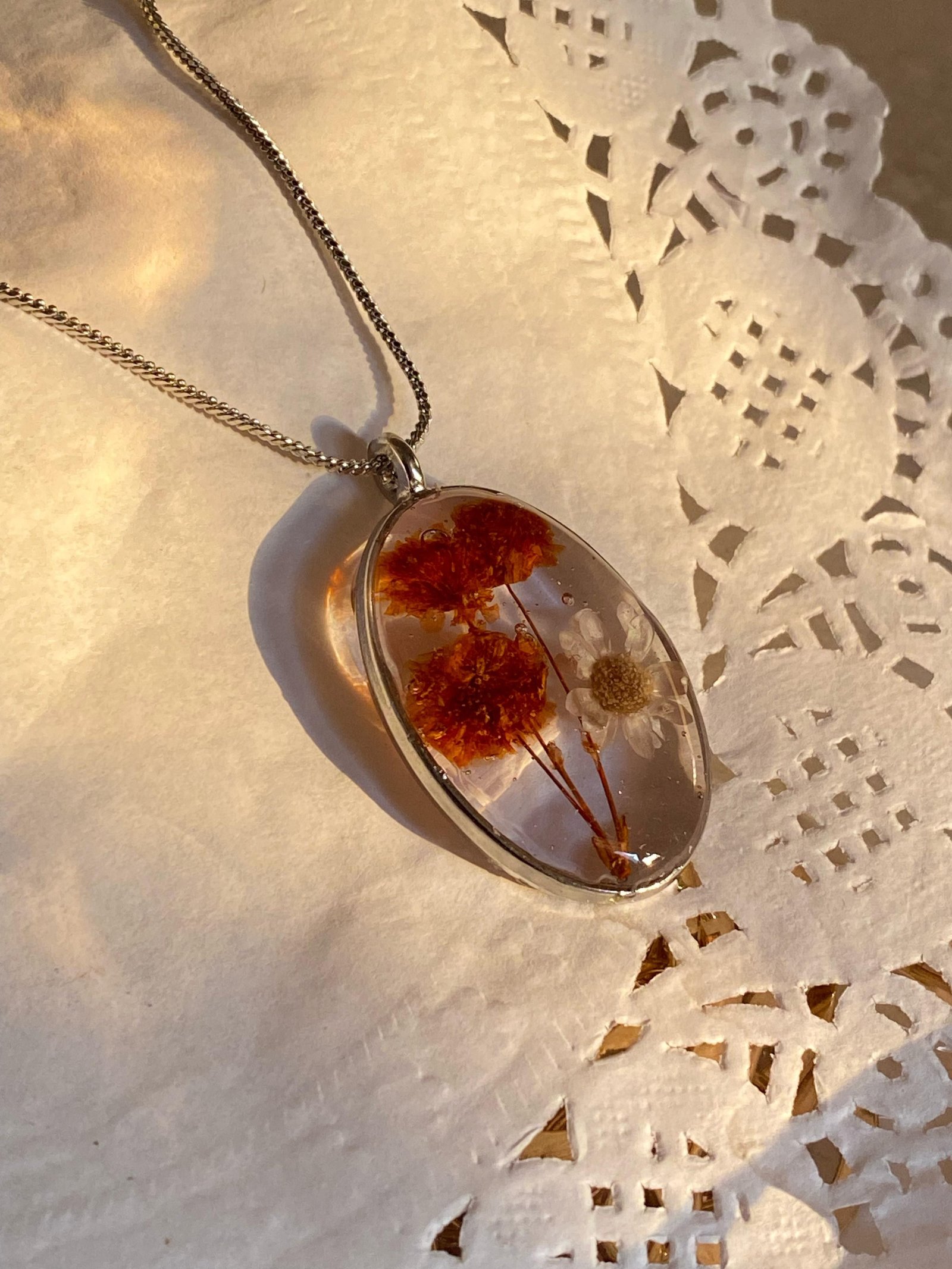 The same shape in silver, resting on white lace