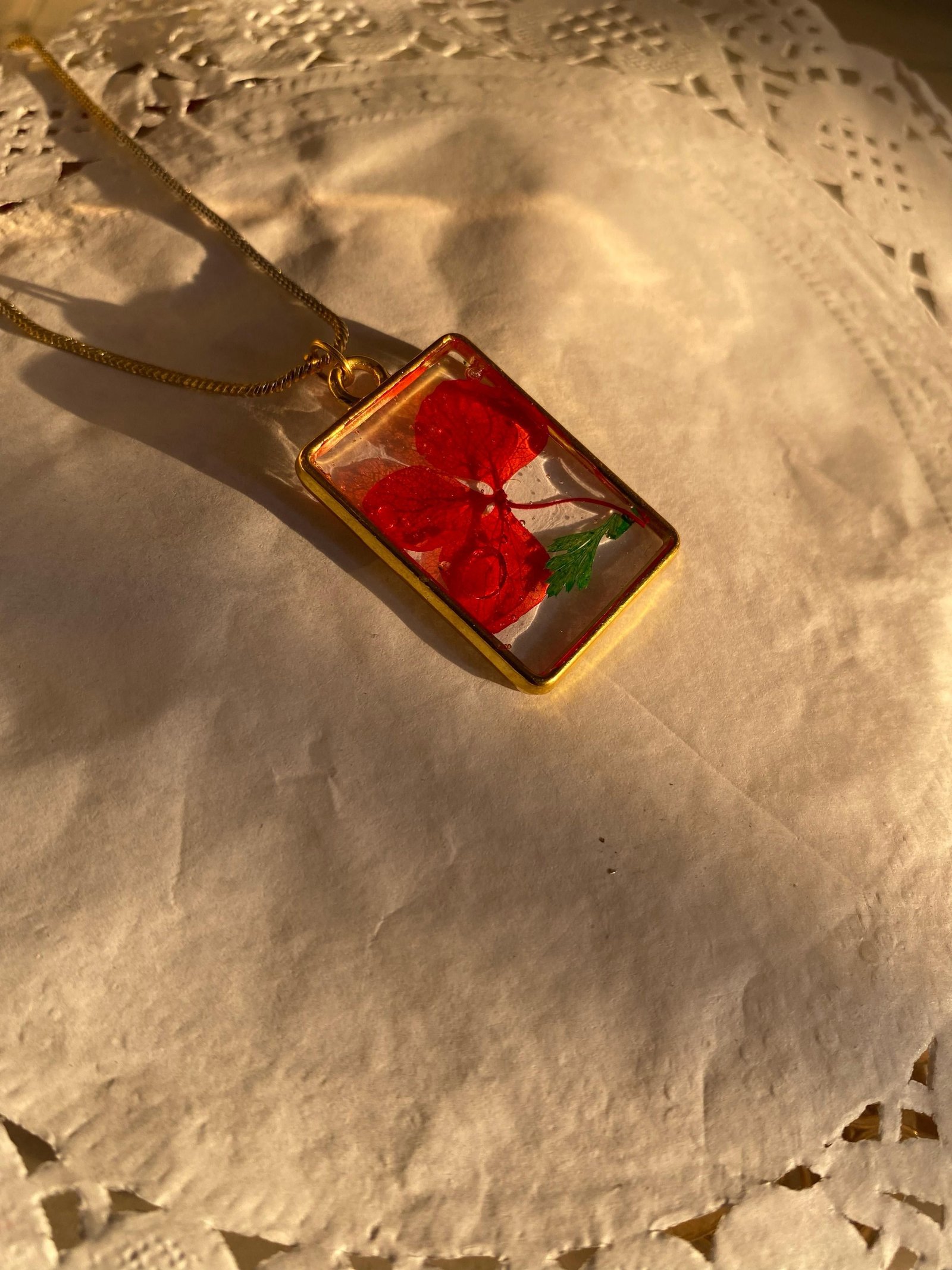 A version holding red blooms and a green leaf