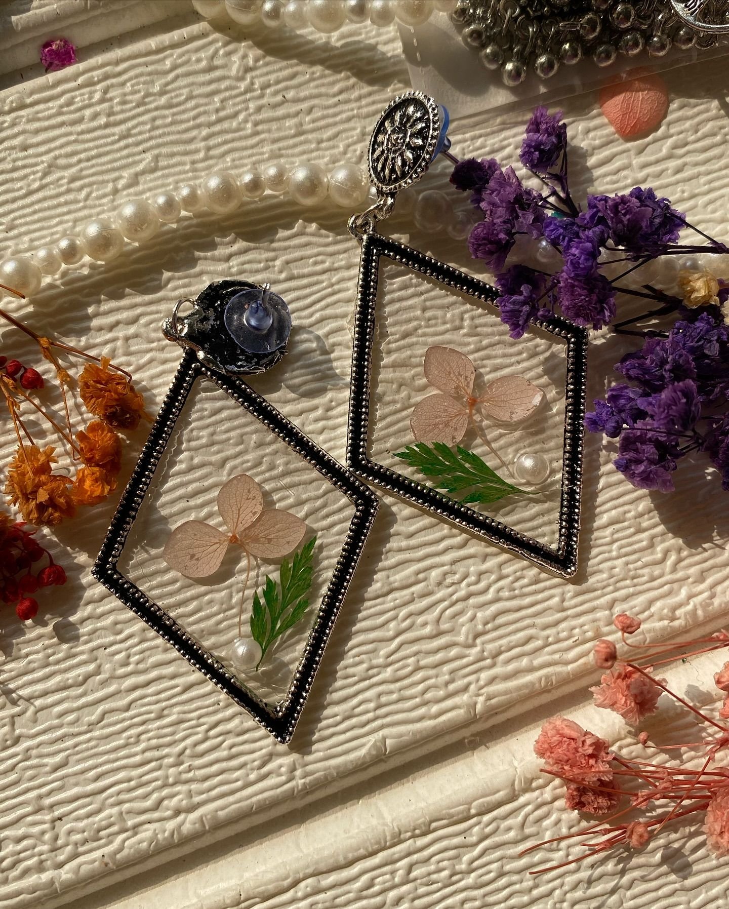 The same pair seen from a second angle, the dried flowers scattered beside them