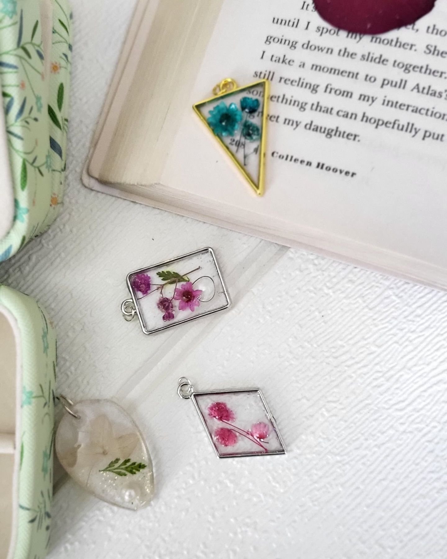 The pale pendant with its fern, resting in the box